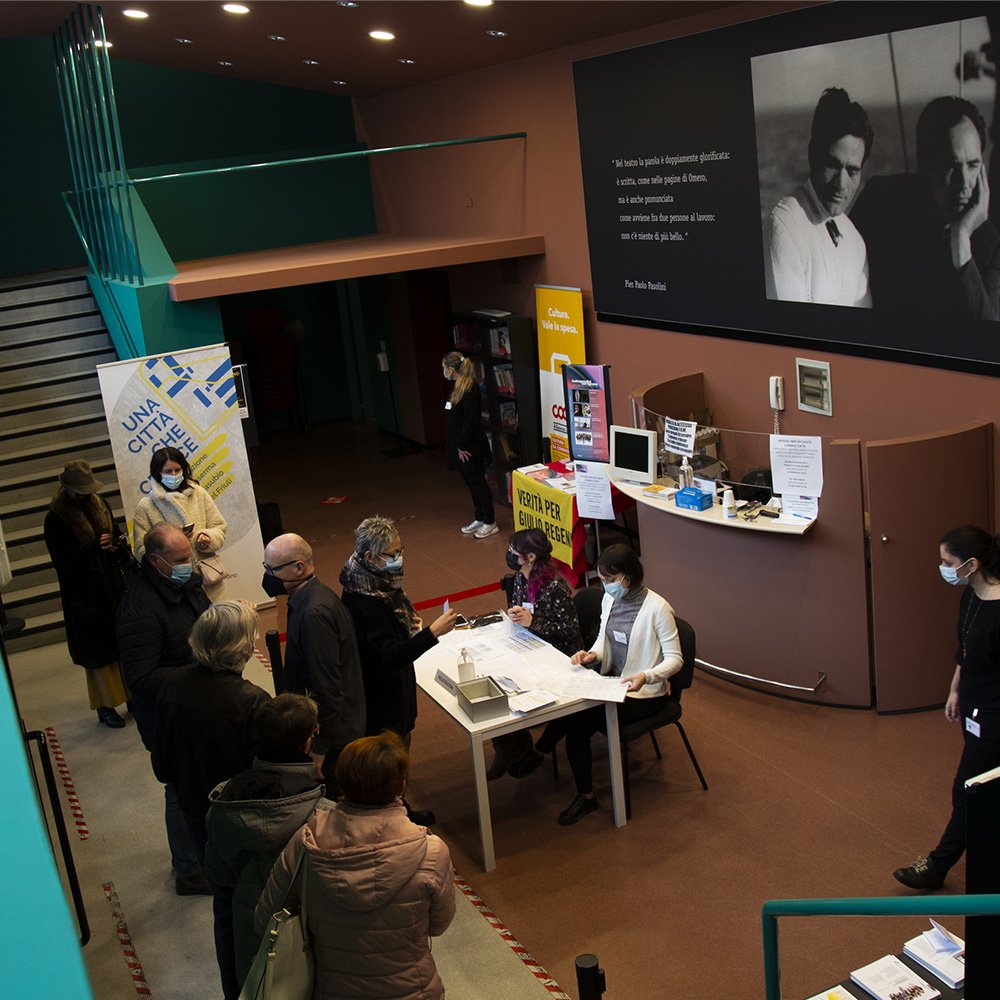 Creaa Progetti: Una città che cresce Hall del Teatro Pasolini di Cervignano del Friuli, con persone in fila per registrare la loro presenza all'evento.